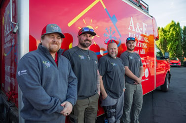 4 A&E techs stand in front of a red A&E company van.