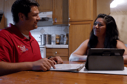 An A&amp;E salesman walks a buyer through the documents of their newest HVAC purchase.