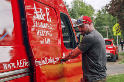 An A&E HVAC technician is opening the door to an A&E work van to get his tools before a job.