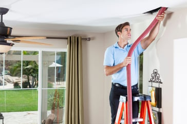 Man cleaning air ducts in home.