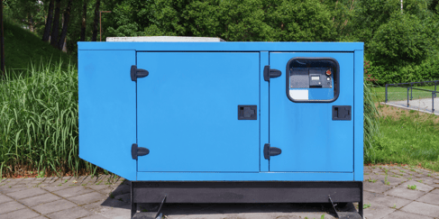 A blue outdoor generator sits on a concrete slab, the keypad visible in the top right.