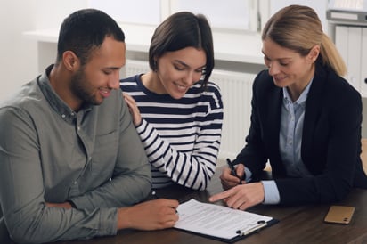 A couple sits down with an HVAC salesperson, walking through their HVAC quote before final approval.