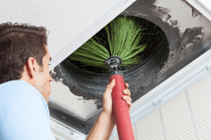 An HVAC tech works on cleaning a residential duct system.