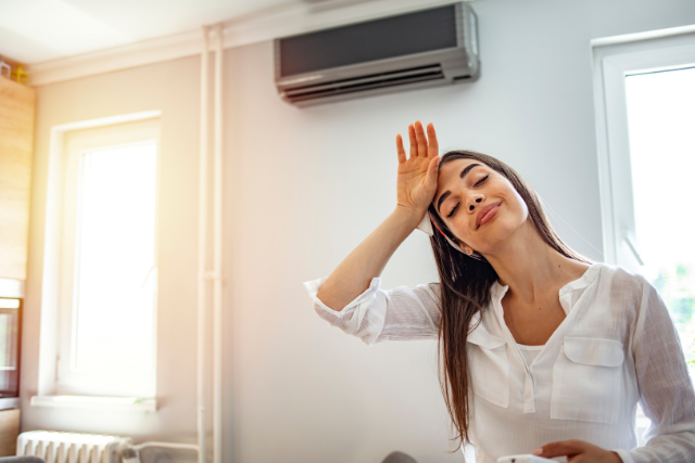 A woman relaxes in a chilled room of her home, which is kept cool by her energy efficient AC unit.