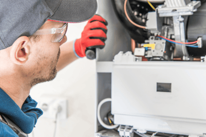 An HVAC tech peers into a furnace to start the diagnosing process.