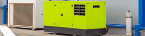 A narrow, long shot of a bright green generator contrasting with the white wall behind it.