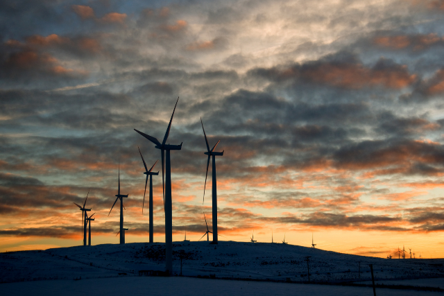 The sun sets behind Goldendale, WA wind turbines.