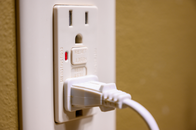 A plug rests in a standard power outlet.