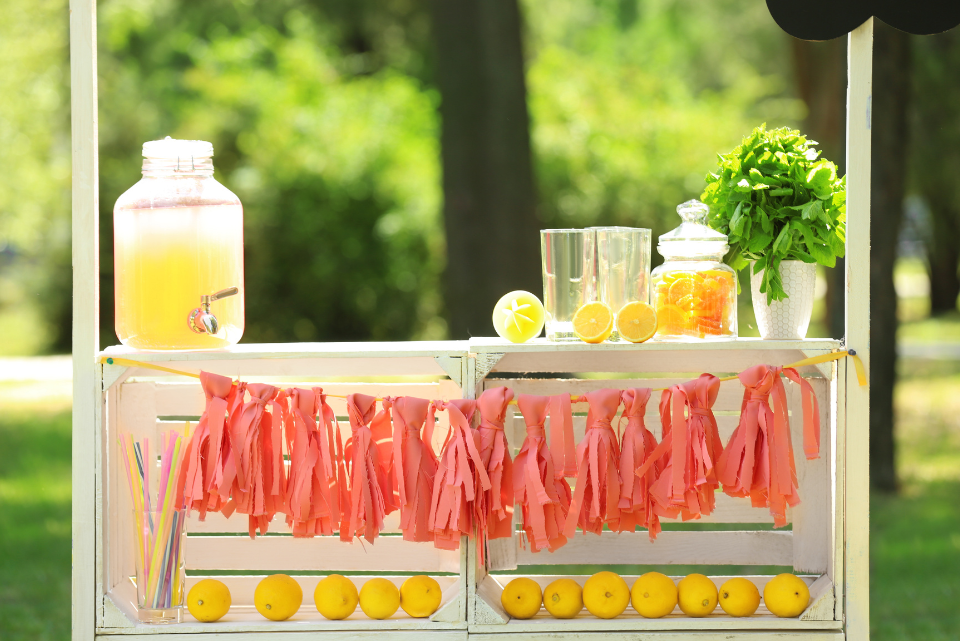 Lemonade stand with orange ribbon across the front to draw attention and customers.