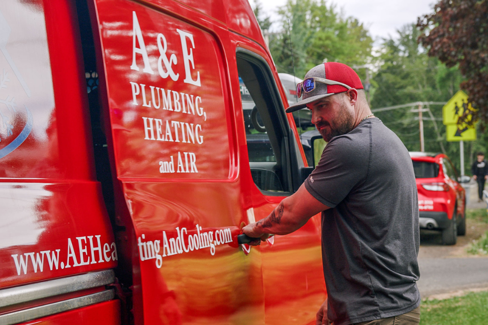 A&E technician opening the door of a bright red A&E company van.