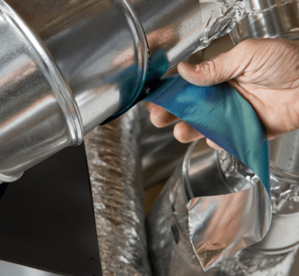 A person applies foil tape to a residential HVAC duct system.