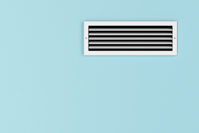 A white HVAC vent sits in the top upper right of an all-blue wall.