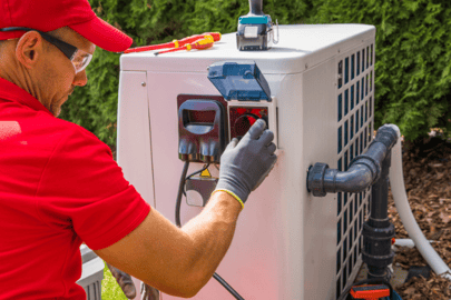 An A&amp;E HVAC tech performs maintenance on an outdoor heat pump unit.