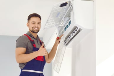 An HVAC technician works on an HVAC mini split system in a home.