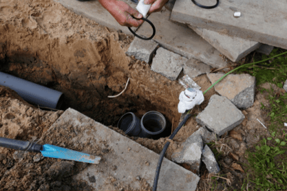 A trench reveals residential sewer lines being replaced.