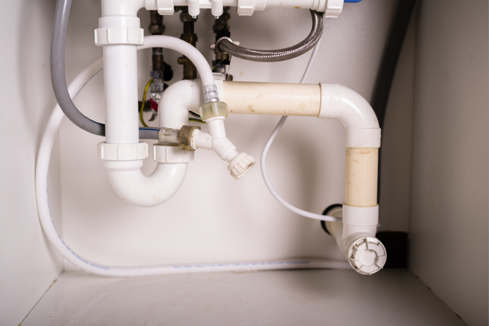 PEX piping sits under a sink, the pipes currently in use.