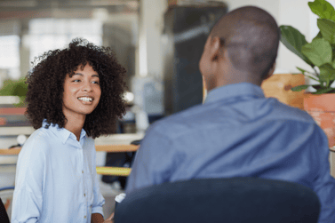 A man and a woman are deep in a conversation in a very relaxed environment, like an HVAC-regulated kitchen.