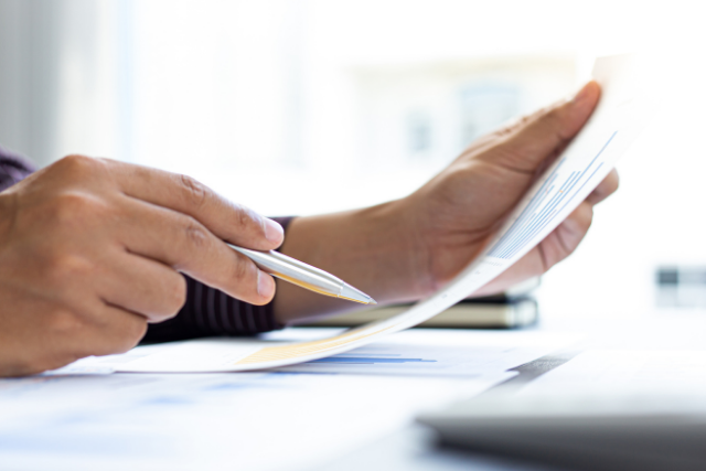 A person reviews the tax paperwork they're about to submit to qualify for HVAC IRA credits and rebates.