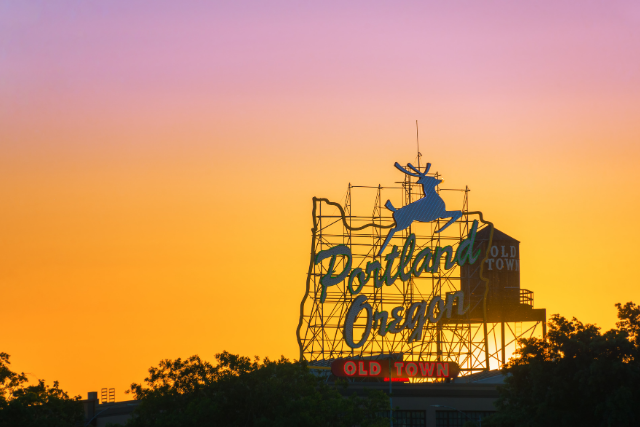 The sun sets behind Portland, Oregon's iconic deer sign, with 