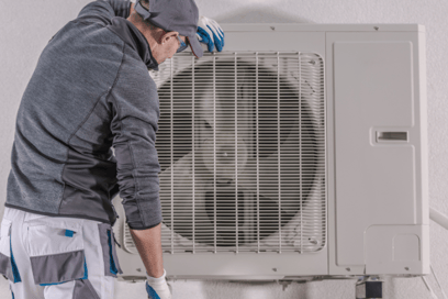 An HVAC tech leans on a newly installed HVAC unit, amazed at how quiet it is during operation.