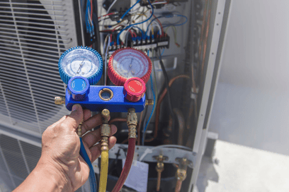 An HVAC tech tests the refrigerant levels on an HVAC system.