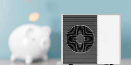 In the foreground is an HVAC heat pump unit with a piggy bank and coins in the background, implying money savings. 