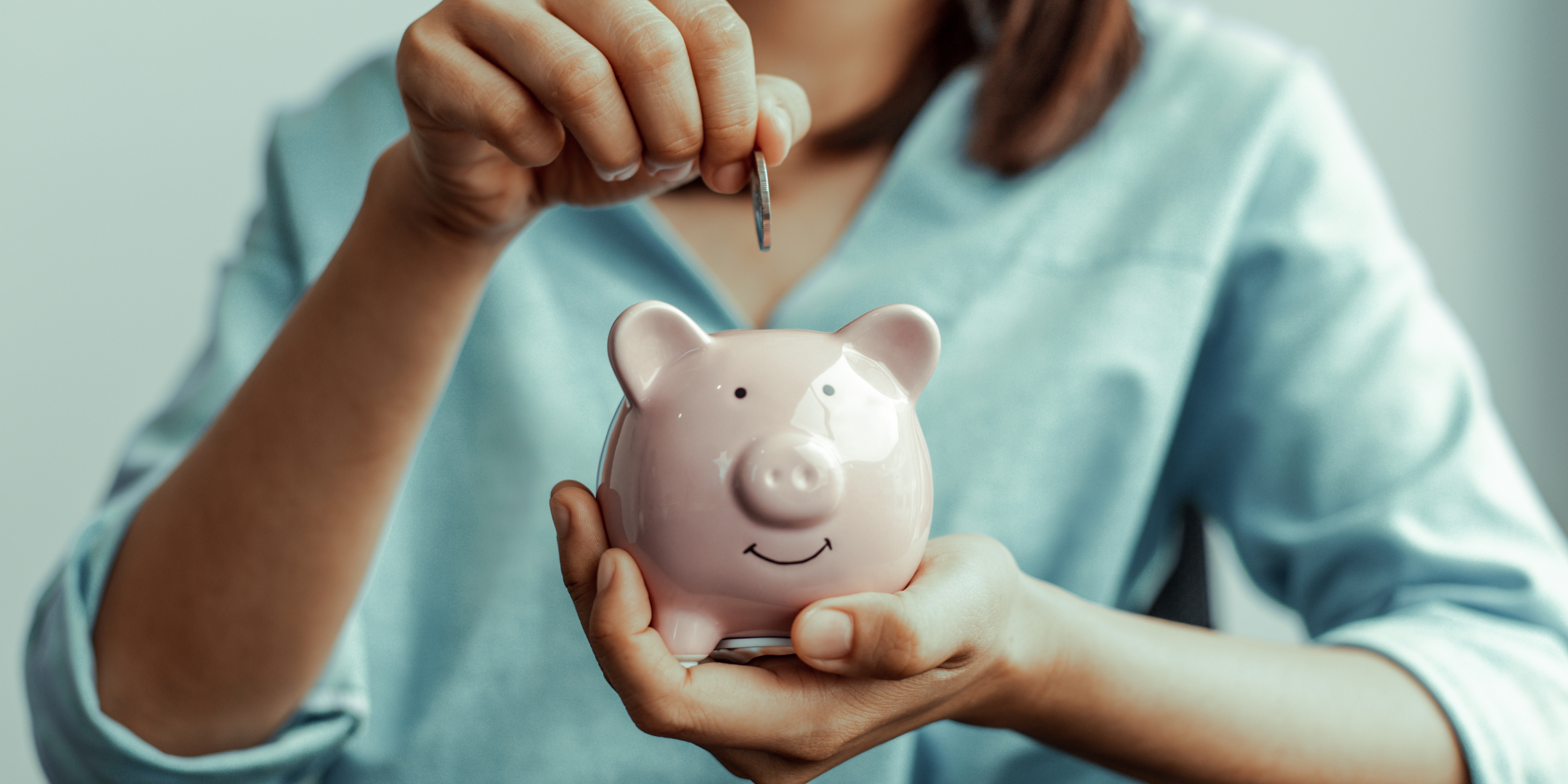Woman putting a coin in a piggy bank, signifying great savings with The Comfort Club.